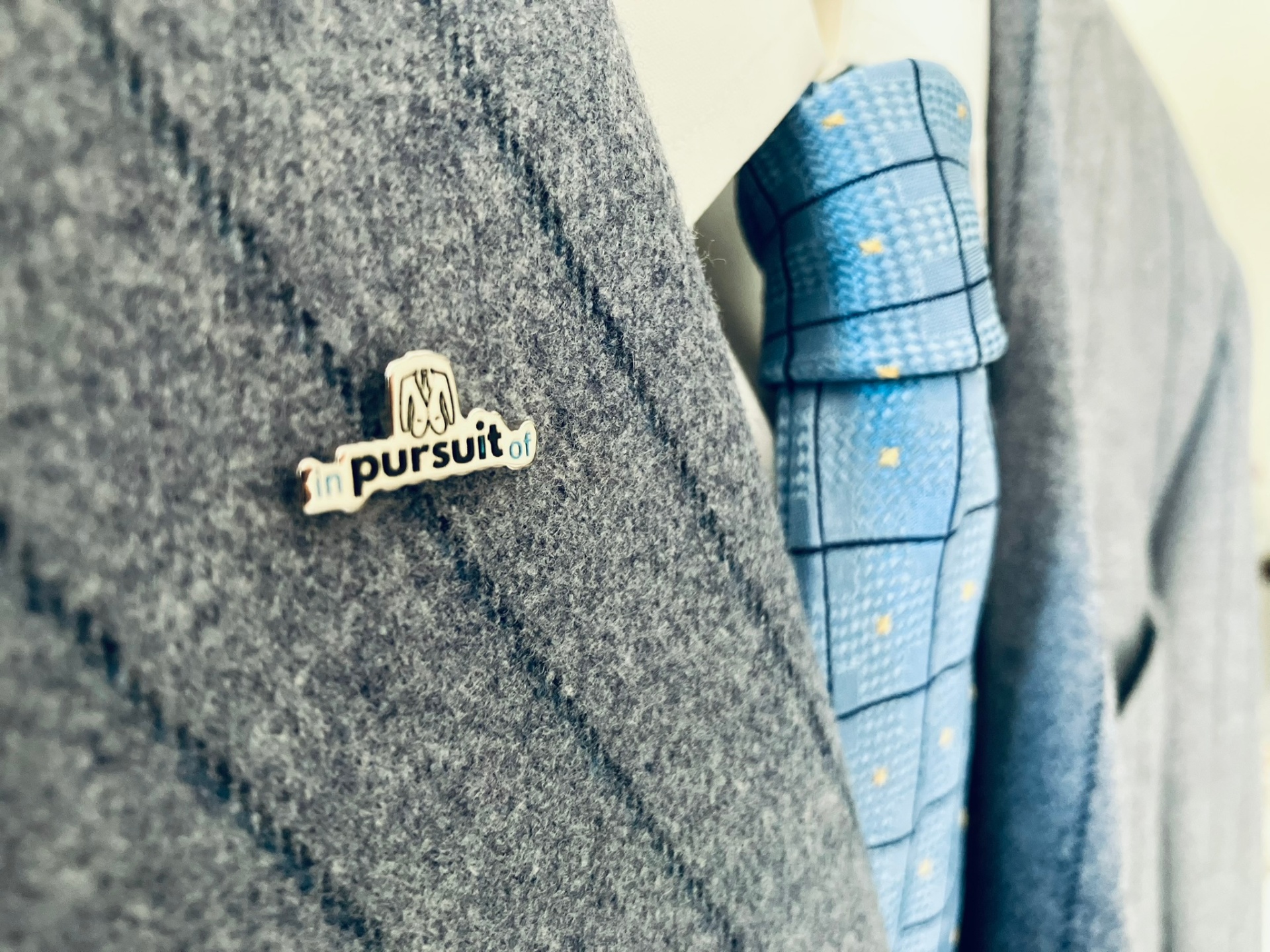 Close-up of a tailored navy suit lapel and patterned blue and gray tie